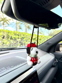 snoopy hanging from the rearview mirror of a car